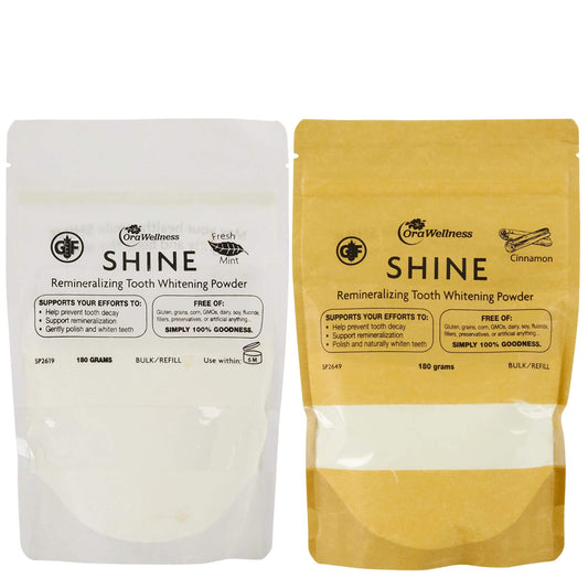 OraWellness bulk bags of mint and cinnamon Shine tooth powder in awhite bag and a yellow bag